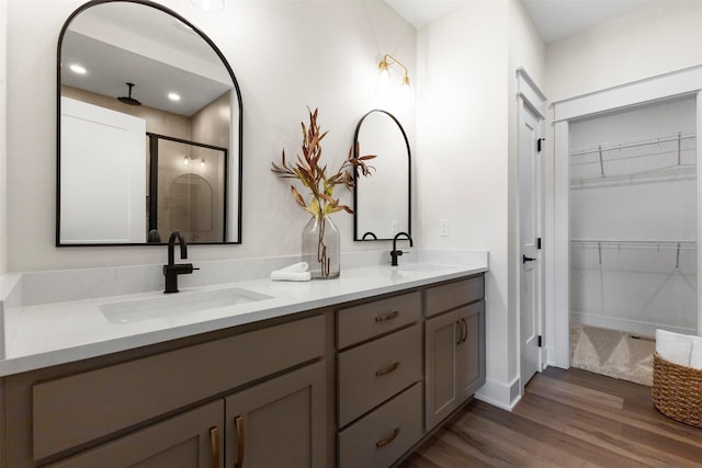 bathroom with vanity, an enclosed shower, and hardwood / wood-style flooring