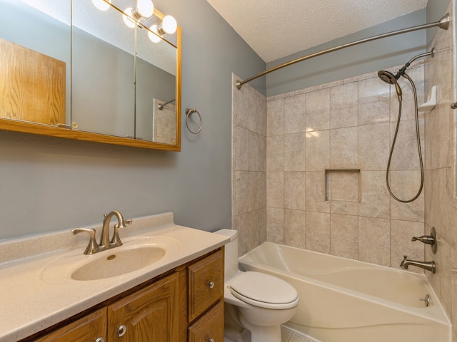 full bathroom featuring a textured ceiling, toilet, vanity, and tiled shower / bath combo