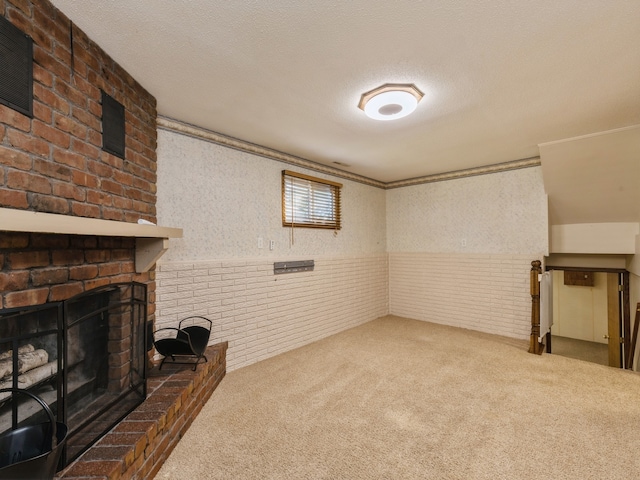 basement featuring a fireplace, carpet floors, and a textured ceiling