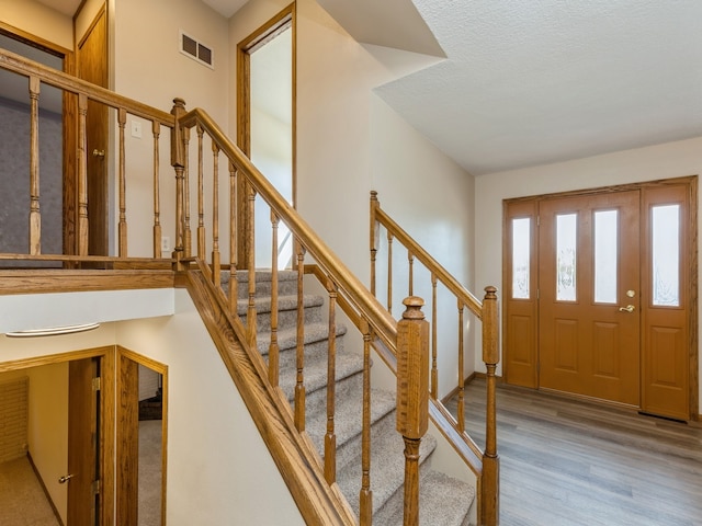 entrance foyer with light hardwood / wood-style floors and a textured ceiling