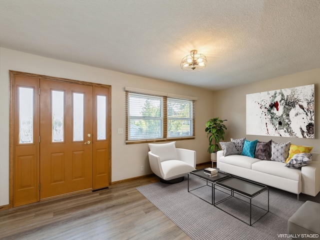 living room with a textured ceiling and light wood-type flooring