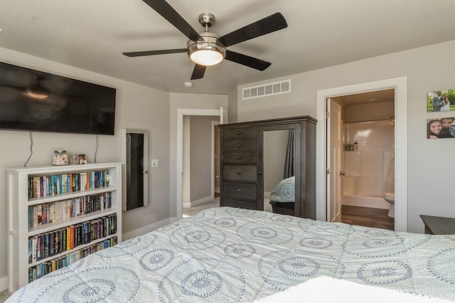 bedroom featuring ensuite bath, ceiling fan, and wood-type flooring