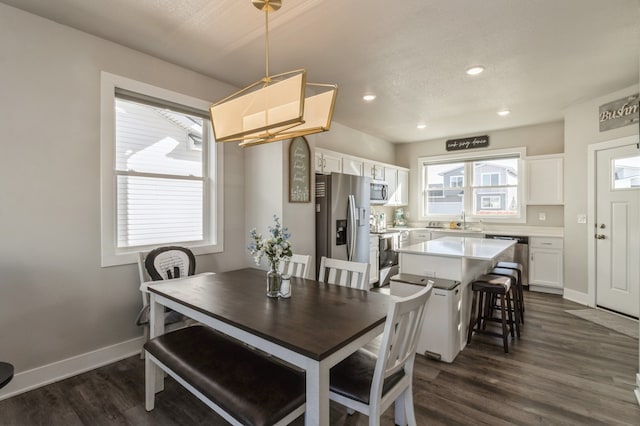 dining area with dark wood-type flooring and sink