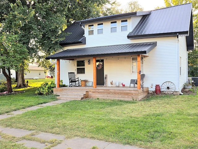 view of front of property featuring metal roof, a porch, and a front yard