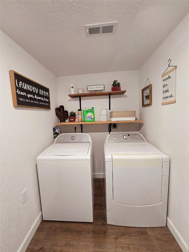 clothes washing area featuring a textured ceiling, laundry area, separate washer and dryer, dark wood-style flooring, and visible vents