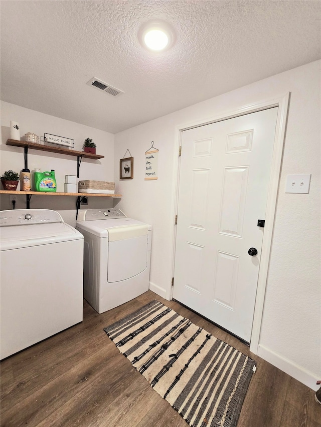 laundry room with dark wood-style floors, laundry area, visible vents, and separate washer and dryer