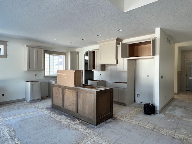 kitchen with a textured ceiling and gray cabinetry