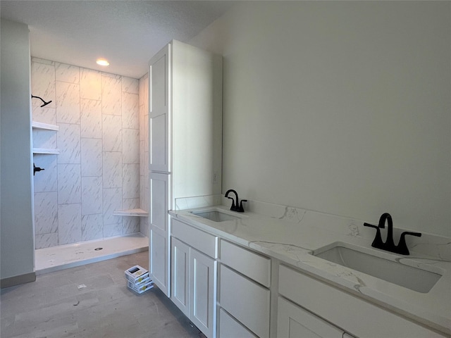 bathroom with vanity and tiled shower