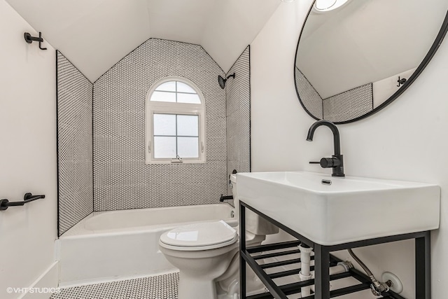 bathroom featuring washtub / shower combination, toilet, and lofted ceiling