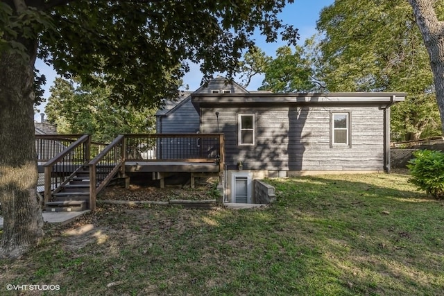 back of property featuring a deck and a yard