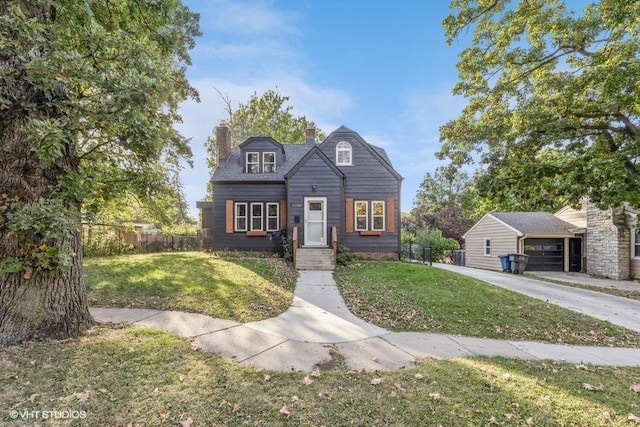 view of property with an outbuilding, a front yard, and a garage