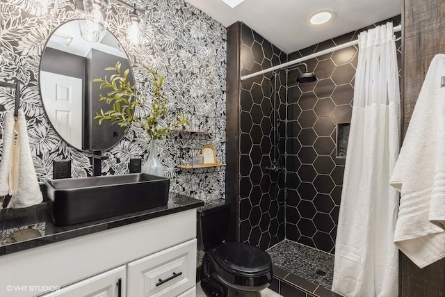 bathroom with vanity, toilet, and tiled shower