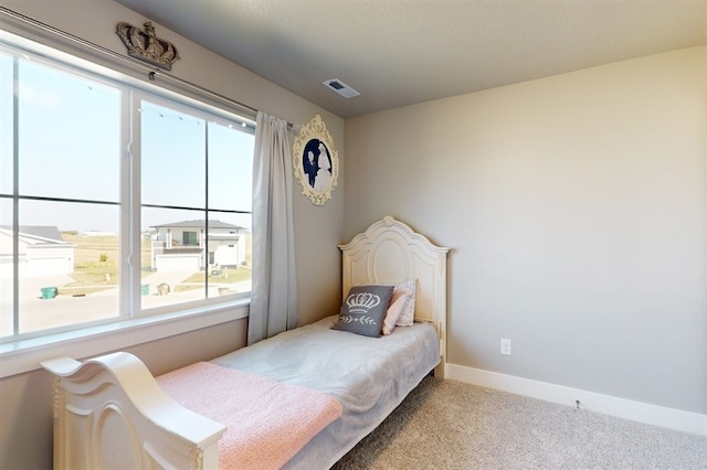 bedroom with light carpet and multiple windows