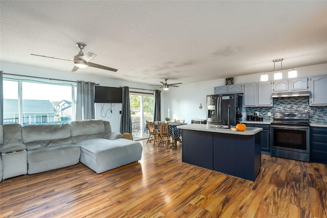14603 Westbrook Dr, Urbandale, IA 50323 - kitchen featuring under cabinet range hood, light countertops, black fridge with ice dispenser, stainless steel range with electric stovetop, and open floor plan