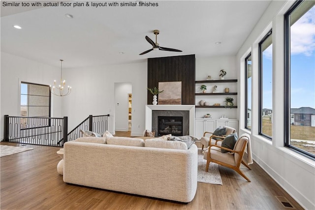 living room with an inviting chandelier, wood-type flooring, and a fireplace