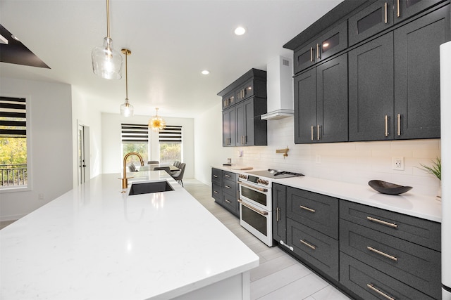 kitchen featuring plenty of natural light, hanging light fixtures, range with two ovens, and custom range hood