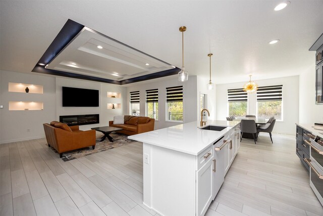 kitchen with pendant lighting, plenty of natural light, an island with sink, and sink