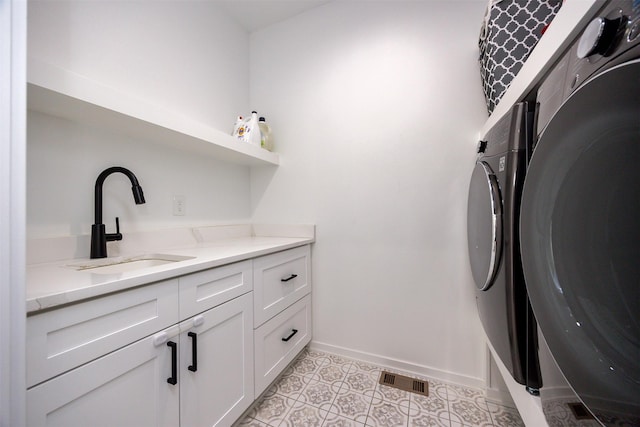 laundry room with washing machine and dryer, cabinets, sink, and light tile patterned floors