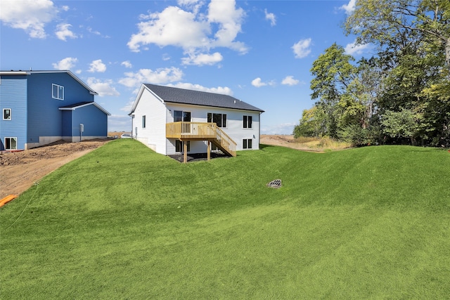 rear view of property featuring a deck and a lawn