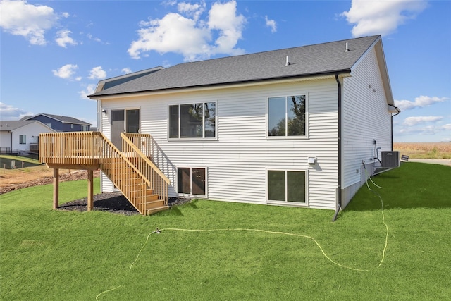 rear view of house featuring a wooden deck, central AC unit, and a lawn