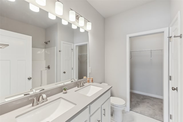 bathroom with walk in shower, vanity, and toilet