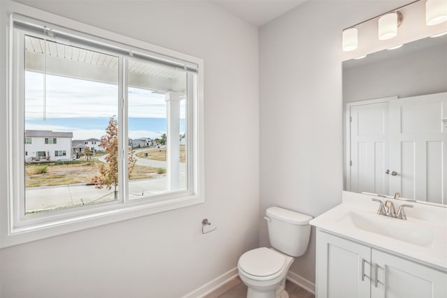 bathroom featuring a wealth of natural light, vanity, and toilet