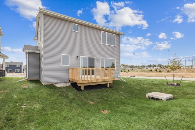 back of property with a yard, a wooden deck, and central air condition unit