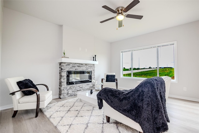 1703 Gordon Ct, Norwalk, IA 50211 - living area with wood finished floors, a stone fireplace, and a ceiling fan
