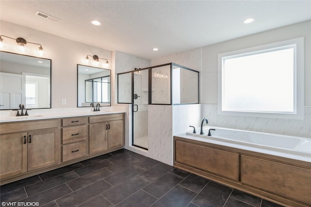 bathroom with vanity, tile patterned floors, independent shower and bath, and a textured ceiling