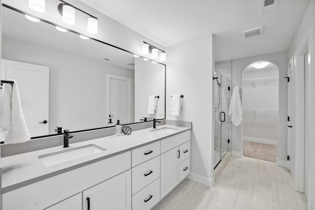 bathroom with walk in shower and vanity