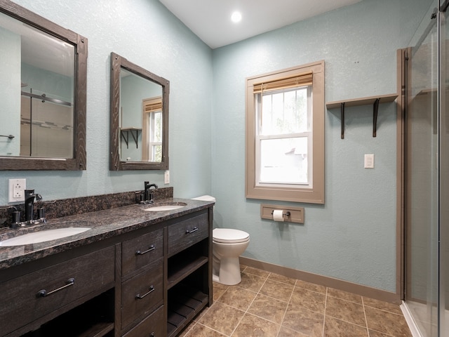 bathroom featuring tile patterned flooring, a shower with door, vanity, and toilet