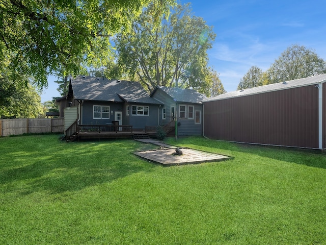 rear view of house with a yard and a wooden deck