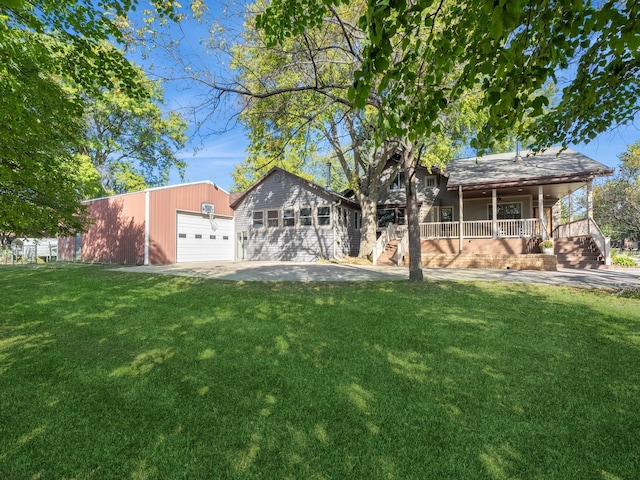 back of house featuring a porch, a lawn, and a garage