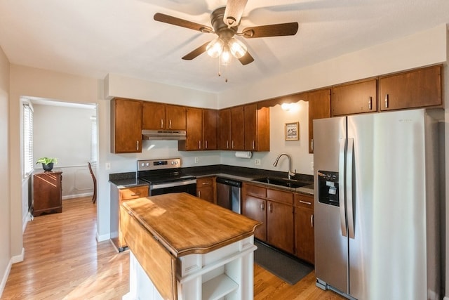 kitchen with appliances with stainless steel finishes, ceiling fan, sink, and light hardwood / wood-style flooring