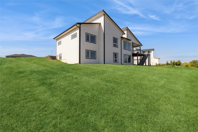 back of house featuring a deck and a lawn