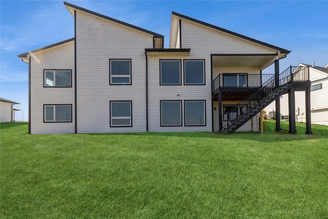 rear view of house with a wooden deck and a lawn