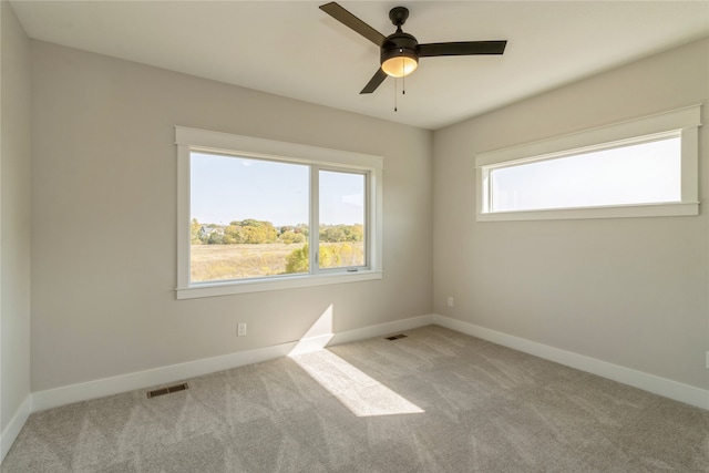 empty room featuring ceiling fan and light colored carpet