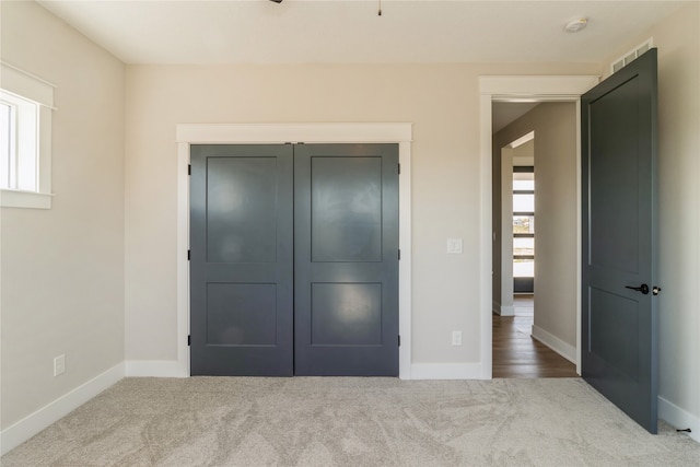 unfurnished bedroom featuring a closet, carpet flooring, and multiple windows