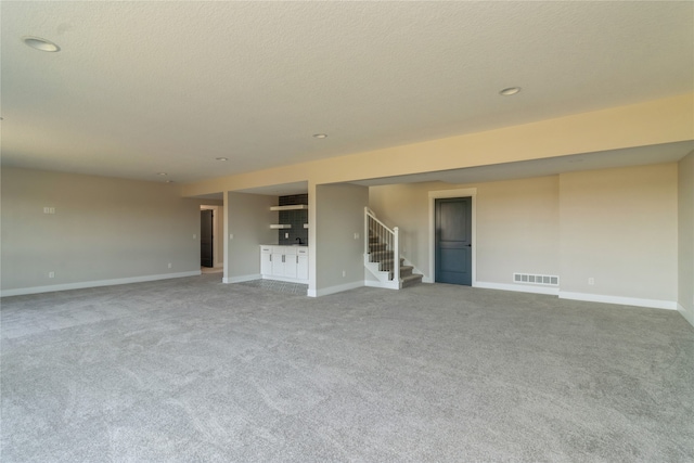 spare room with a textured ceiling and carpet flooring