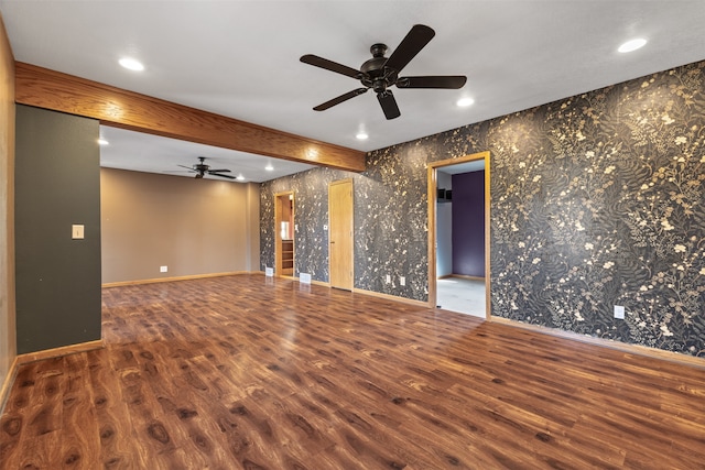 spare room featuring beamed ceiling, dark hardwood / wood-style floors, and ceiling fan