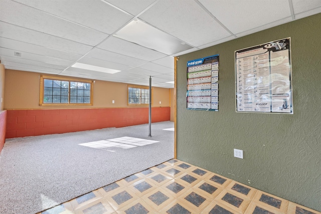 basement featuring carpet flooring and a drop ceiling