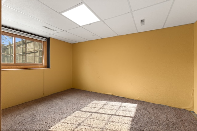 carpeted empty room with a drop ceiling