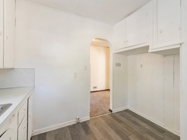 kitchen with crown molding, backsplash, dark hardwood / wood-style floors, and white cabinets