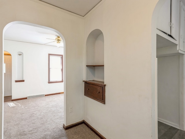 corridor featuring crown molding and dark colored carpet