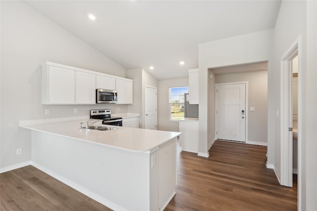 kitchen featuring stainless steel appliances, dark hardwood / wood-style flooring, kitchen peninsula, and white cabinets