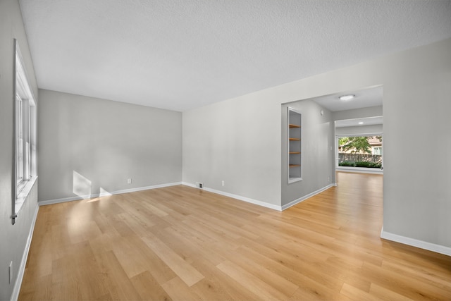 spare room featuring a textured ceiling and light wood-type flooring