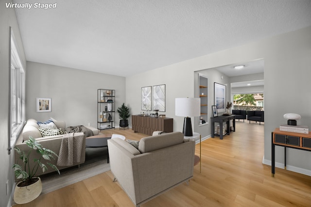 living room featuring light hardwood / wood-style floors and a textured ceiling