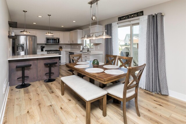 dining room with sink and light hardwood / wood-style floors