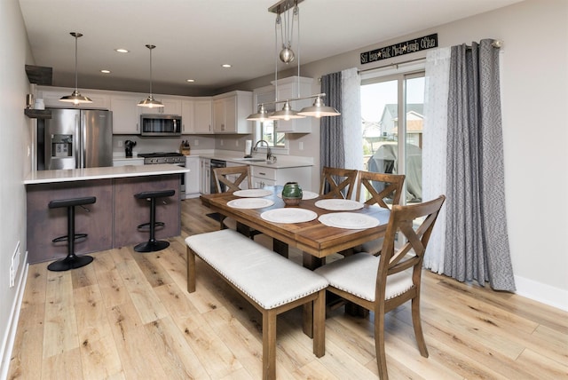 dining space featuring light wood-style flooring, recessed lighting, and baseboards