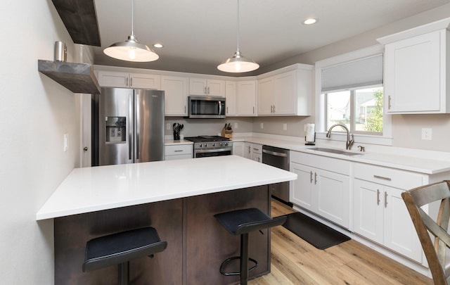 kitchen featuring a sink, a breakfast bar, white cabinetry, and stainless steel appliances